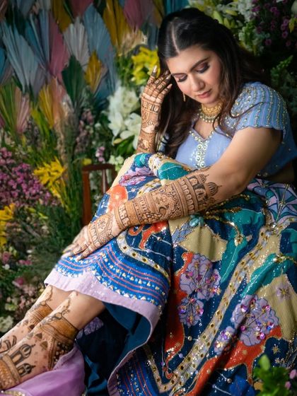 A full-length shot showing the bride's complete look, from her stunning lehenga to her intricate hand and feet mehendi.