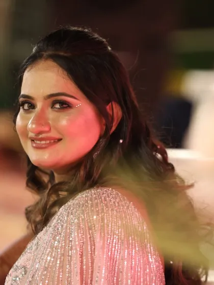 A candid shot of the bride at her reception. The subtle glitter on her cheekbones catches the light beautifully, adding a touch of magic.