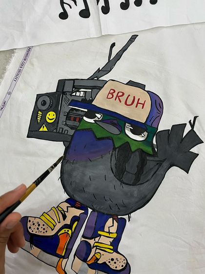 Unleashing some creativity on a cotton shirt. This piece features a cool pigeon character with a "BRUH" cap and a boombox, blending street style with a touch of humor.