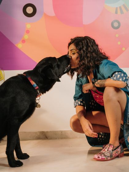 A moment of love and connection between the artist and her dog, Kai, in front of a vibrant mural. Art and love are the same thing.