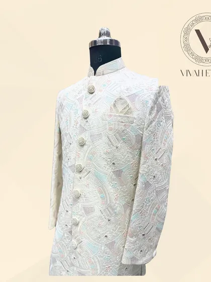 A detailed side-angle shot of the ivory sherwani, focusing on the sleeve and button placket. This view highlights the density and craftsmanship of the pastel-colored embroidery against the ivory base fabric.