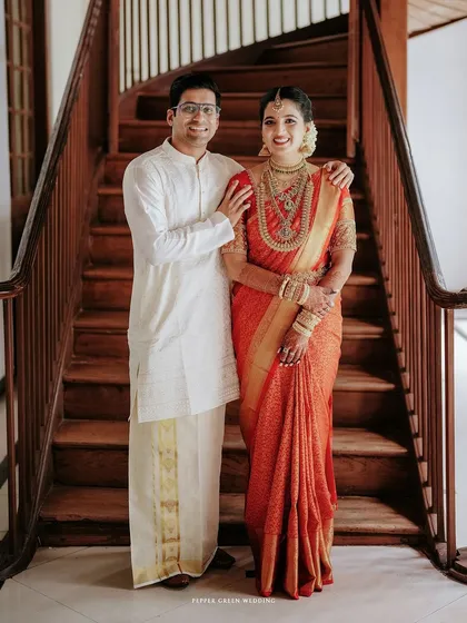 A classic portrait of the couple on a wooden staircase, their traditional attire looking elegant against the heritage backdrop.