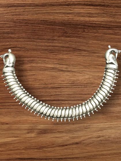 Our popular silver sutarla necklace, shown here in its classic oxidised finish. The piece has a flexible, spine-like design with peacock head ends.