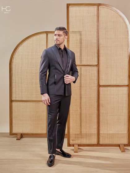 A full-length shot showcasing the powerful stance this black suit provides. Paired with classic black loafers, it's a complete look of modern sophistication.