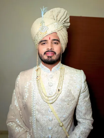 A close-up of the groom's refined look. The subtle makeup enhances his features, perfect for the detailed embroidery of his sherwani and the layered necklace.