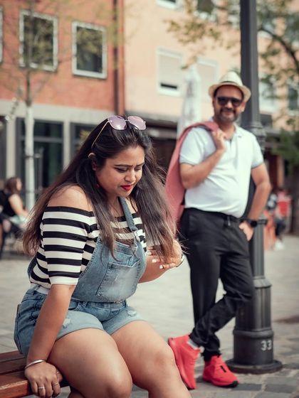 A candid moment from a European pre-wedding shoot, capturing the couple's interaction against a charming city street backdrop.