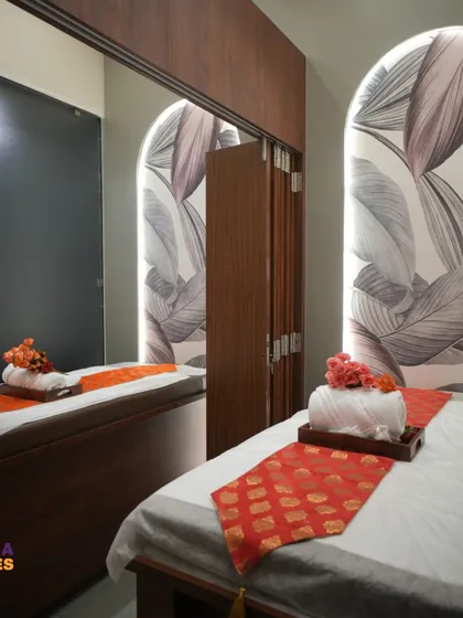 A mirror wall in the treatment area creates a sense of spaciousness. It reflects the calming design elements, like the backlit arch and warm wood tones, making the room feel larger and more immersive.