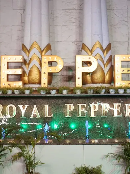 The lit-up sign of the "Royal Pepper" venue, adding to the celebratory night-time atmosphere.