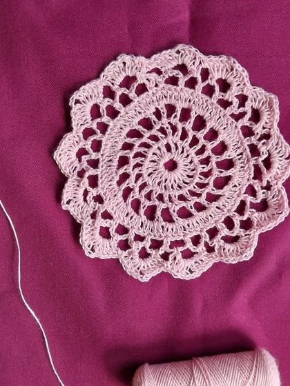A 5-inch pink crochet doily.