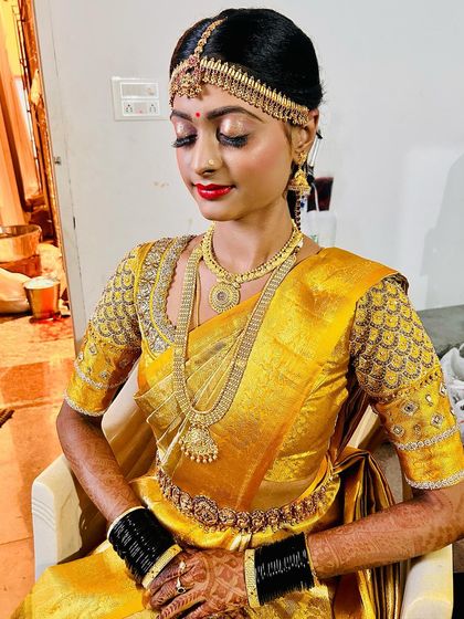 This bride is ready for her big day. The makeup is set to last through all the rituals, and her hair is styled neatly to hold the weight of the traditional head jewellery.