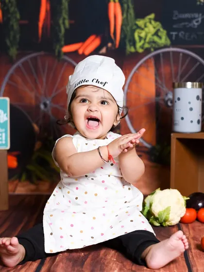 Look at this happy little chef! Fun, themed sessions like this are a wonderful way to capture your baby's budding personality and create truly unique portraits.