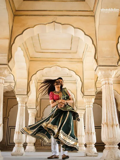 A joyful moment captured as the groom twirls his bride in the arched corridors of a Jaipur palace. This image showcases our expertise in destination pre-wedding shoots, blending movement and magnificent architecture.