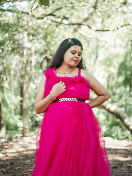 A closer look at the delicate ruffled neckline and elegant belt of this magenta maternity gown. It's all in the details.