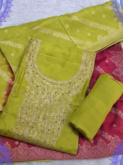 A vibrant lime green dress material with a contrasting pink Banarasi dupatta. The top has simple embroidery, allowing the bright colors to make a bold statement.