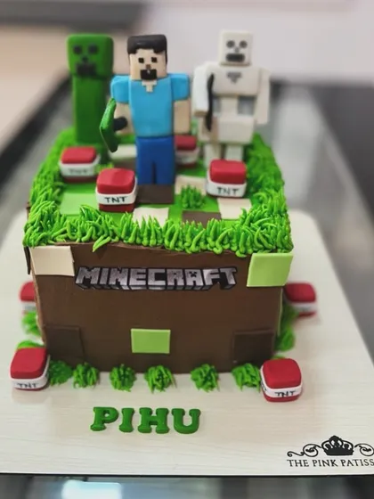 Another take on the popular Minecraft theme, this time in a square cake that looks like a block from the game. It's topped with detailed fondant figures of Steve, a Creeper, and a Skeleton.
