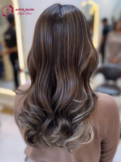The back view of this gorgeous metallic pearly ash balayage. Notice the seamless transition from the natural root to the cool, light ends, styled in soft waves.