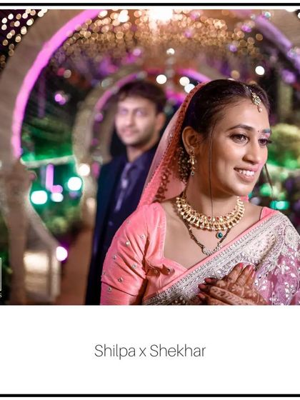A beautiful, soft-focus shot of the bride, Shilpa, with her groom in the background. This style of portraiture adds depth and tells a story, focusing on the bride's happiness while keeping her partner in the frame.