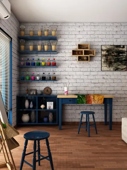 The other side of the art room features an exposed brick wall, open shelving for paints and brushes, and a work table, creating a rustic and practical artist's corner.
