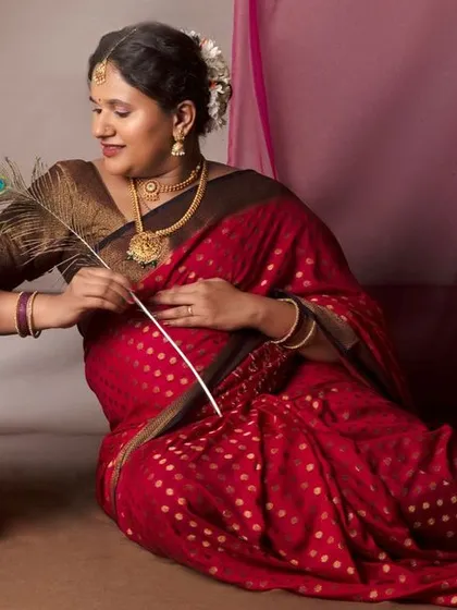 Another graceful pose with a peacock feather, adding a touch of divine beauty to her traditional maternity portrait.