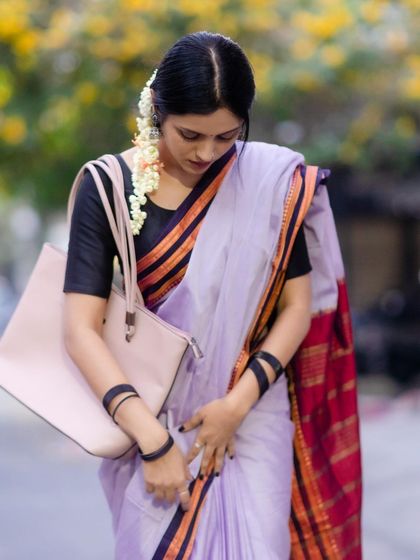 Adjusting the pleats of the Ilkal saree. The texture of the handwoven cotton is visible here, a mark of its authenticity.