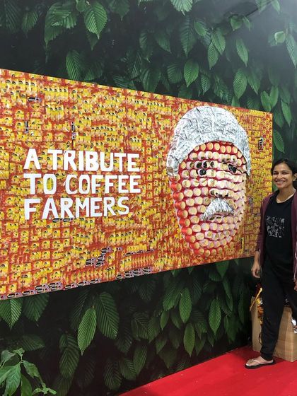 As a tribute to coffee farmers, this portrait was created live at the World Coffee Conference using waste from the Nescafé stall. The face is formed from used paper cups, and the background is a mosaic of empty coffee sachets contributed by visitors, making it a truly collaborative and sustainable piece.