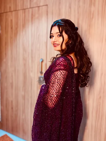 This bride is ready for her reception party. The look features a bold red lip, shimmery eyes, and beautiful cascading curls for a touch of glamour.