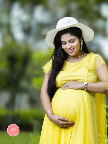 A sunny day and a sunny dress. This lovely outdoor portrait captures the mother-to-be's happy glow, perfectly complemented by her yellow gown and white hat.