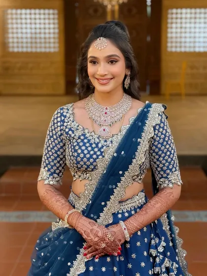 A minimal glam look for a reception, featuring a sparkling blue lehenga and an effortless high ponytail.