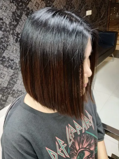 The classic bob haircut requires precision and an eye for detail. Here, we've created a sharp, clean line that enhances the jawline and provides a timeless, chic look that is easy to manage.