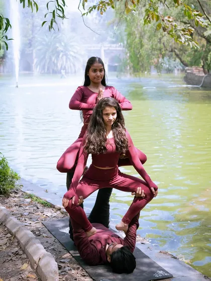 The full view of our three-person acroyoga formation by the water, a beautiful blend of nature and yogic art.