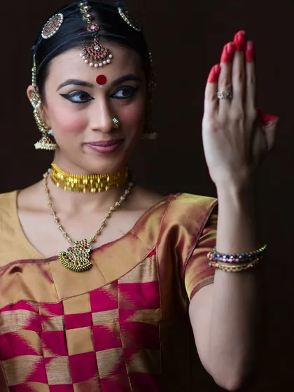 A moment of quiet reflection before the storm of the performance. In this close-up portrait, the intricate details of the Bharatanatyam costume, makeup, and the calm expression tell a story of dedication and anticipation.