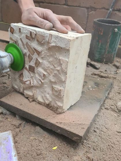 Grinding down the surface of our experimental block to expose the wood chips within. This prototyping phase is where we discover new textures and sustainable material applications for our projects.