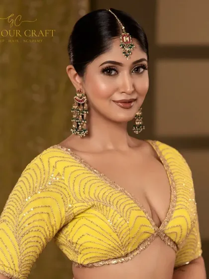 This close-up highlights the intricate details of the jewelry and the vibrant yellow blouse. The model's happy expression brings a lot of life and energy to the portrait.