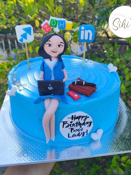 A "Boss Lady" cake for a corporate celebration. This design features a custom fondant figurine of a professional woman with her laptop, surrounded by company logos.
