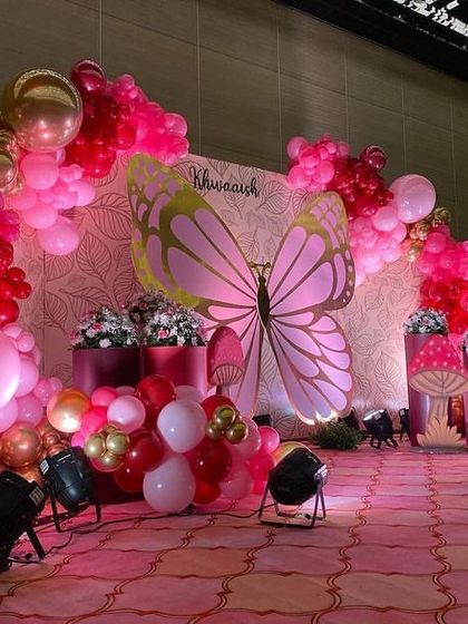 Another angle of the pink and red butterfly stage, showing the arrangement of props and the rich color combination.