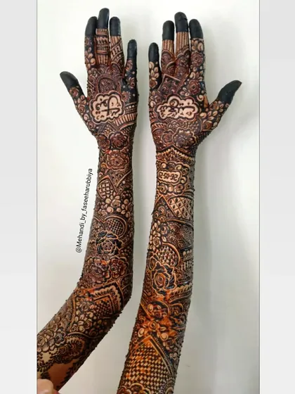 A full-length view of Simran's bridal arms, showcasing the dense and detailed patterns from hand to elbow.