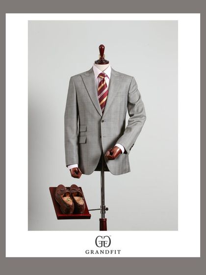 The full view of the two-piece grey suit, demonstrating its clean lines and balanced proportions. It is a testament to understated elegance.