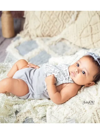 A relaxed, natural pose on a beautiful bohemian-style blanket. This lifestyle approach to baby photography captures authentic and serene moments.