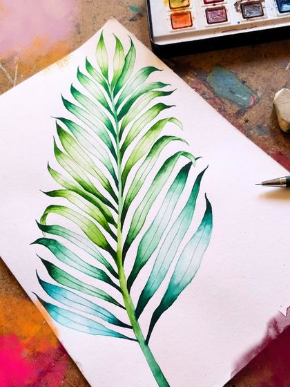 A beautiful watercolor painting of a palm leaf, showcasing smooth blending and gradient techniques. Our watercolor workshops are perfect for learning how to control the paint and create luminous effects.