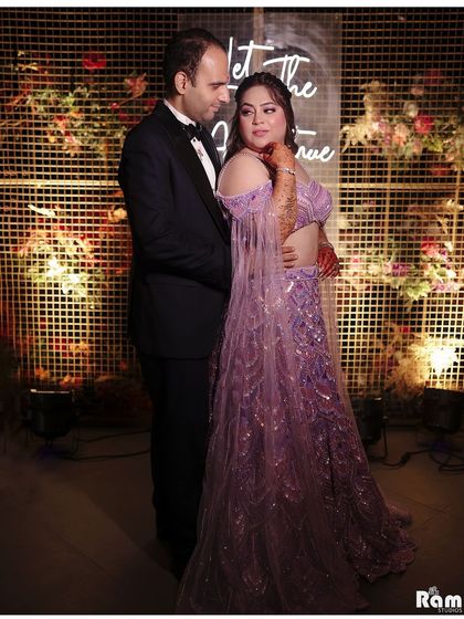 A candid moment from an engagement party, with a neon sign that reads "Let the adventure begin". This shot captures the modern, fun vibe of the celebration.