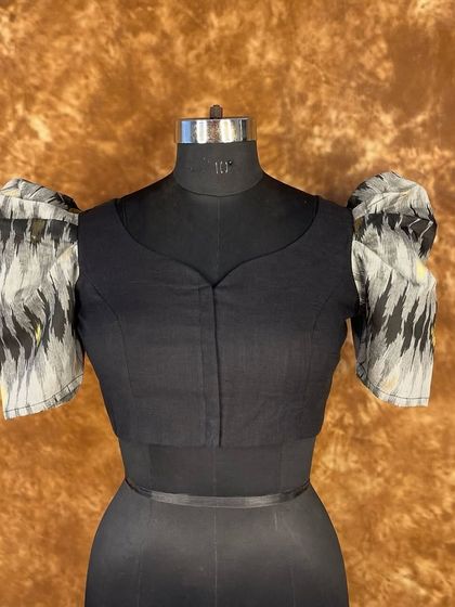 Another look at the classy and bold black puff sleeve blouse. The front-open design with hooks ensures a perfect fit, ready to glam up your saree look for any season.