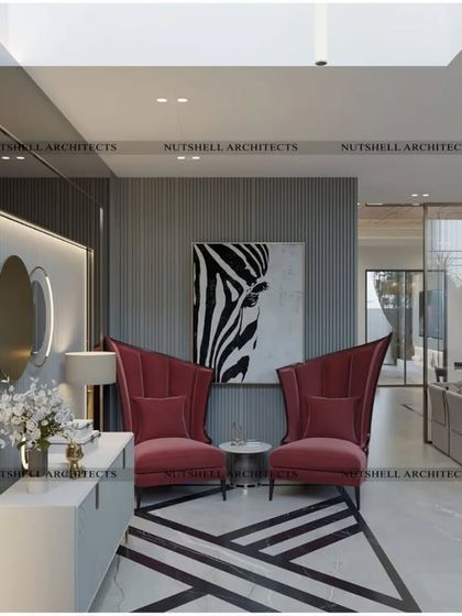 We love creating inviting entry nooks. This corner features bold, high-backed armchairs in a rich magenta, set against a wall of mirrors that enhances the sense of space and light.