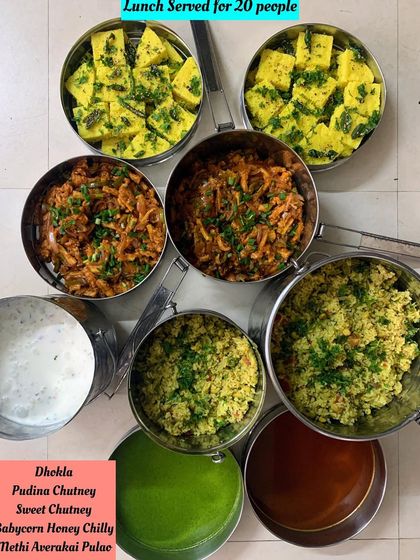 A lunch served for 20 people featuring Dhokla, Babycorn Honey Chilli, and Methi Averakai Pulae.