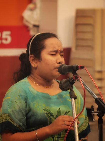 A student deeply focused on her singing during the temple performance.