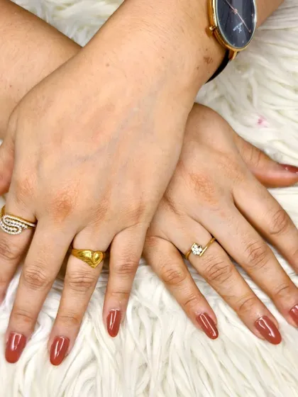 A classic and versatile look featuring a warm, reddish-brown gel polish on medium-length oval nails.