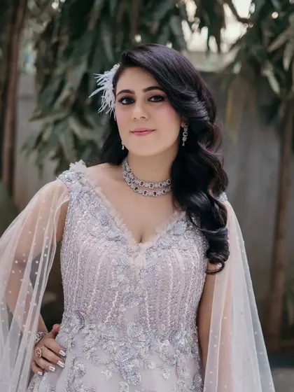 The client posing in her glamorous evening look. The structured waves add a touch of old-school glamour that is both timeless and fashionable.
