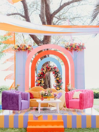 A modern and playful mehendi seating area with a rainbow of arches. The combination of bold colors, clean lines, and plush velvet seating makes this a stylish and comfortable spot for the bride.