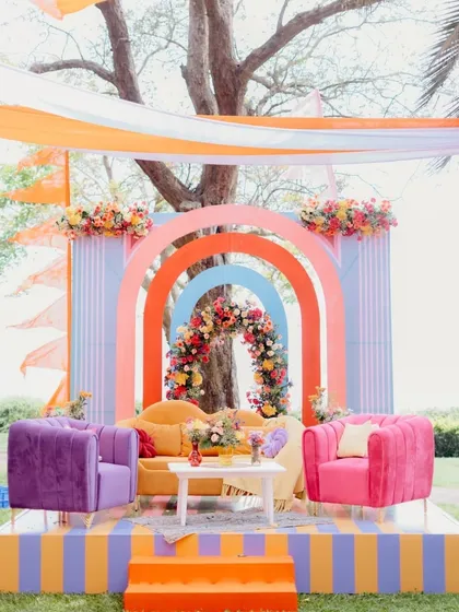 A modern and playful mehendi seating area with a rainbow of arches. The combination of bold colors, clean lines, and plush velvet seating makes this a stylish and comfortable spot for the bride.