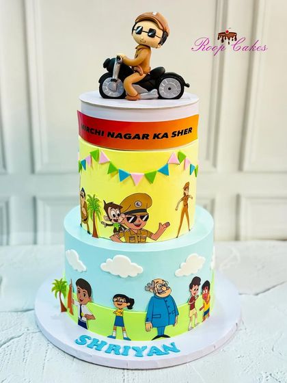 A grand two-tier Little Singham cake. This version features a handcrafted fondant figure of the hero on his motorcycle, ready to protect Mirchi Nagar.