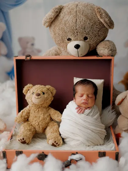 There is nothing more peaceful than a sleeping newborn. Here, I've created a dreamy scene with a cozy swaddle and a collection of teddy bears, highlighting the baby's tiny, perfect features in a safe and serene setting.